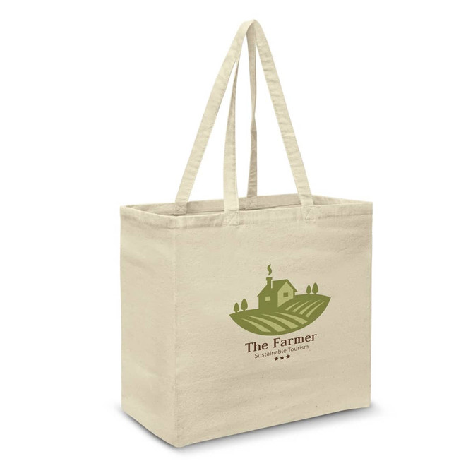 A cream cotton tote bag with a green logo featuring a farm scene and two sturdy handles.