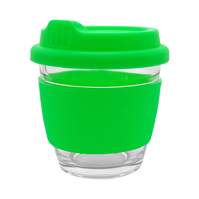 A reusable coffee cup in clear glass with a bright green silicone lid and sleeve, featuring a logo.