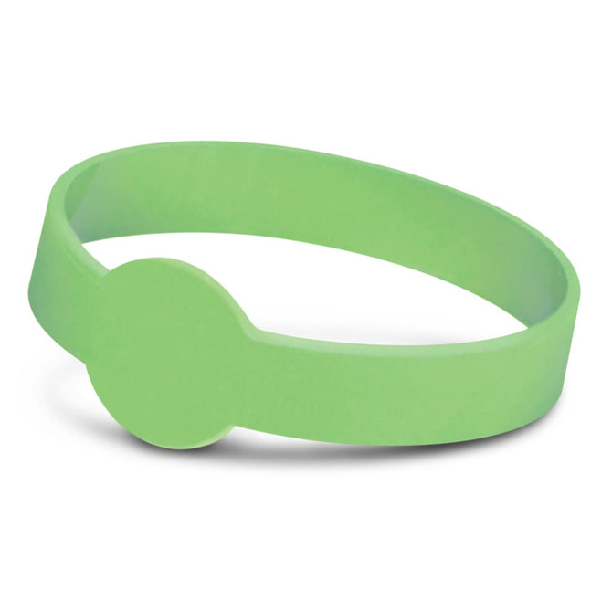 A green silicone wristband with a circular detail, designed to glow in the dark. It features a logo.