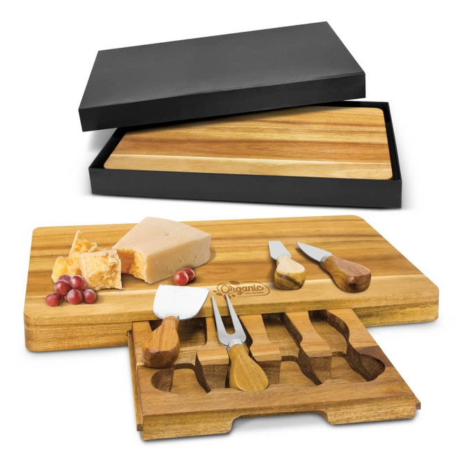 A wooden cheese board in shades of brown, featuring cheese and a set of cheese knives, presented in a black box.