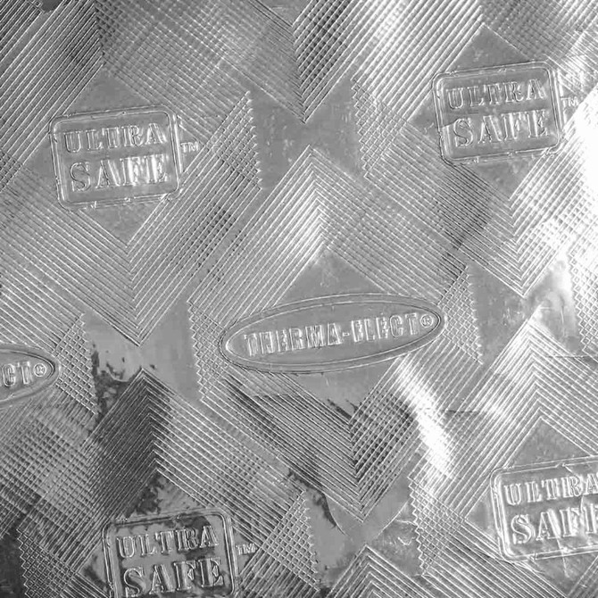A silver textured surface featuring a diamond pattern with branding logos embossed throughout.