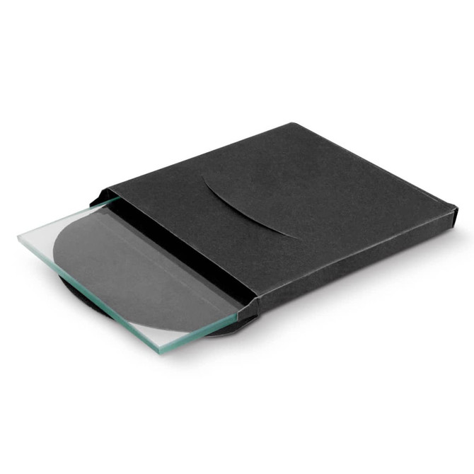 A square, clear glass coaster partially displayed in a black packaging box. The box has a sleek, minimalist design.