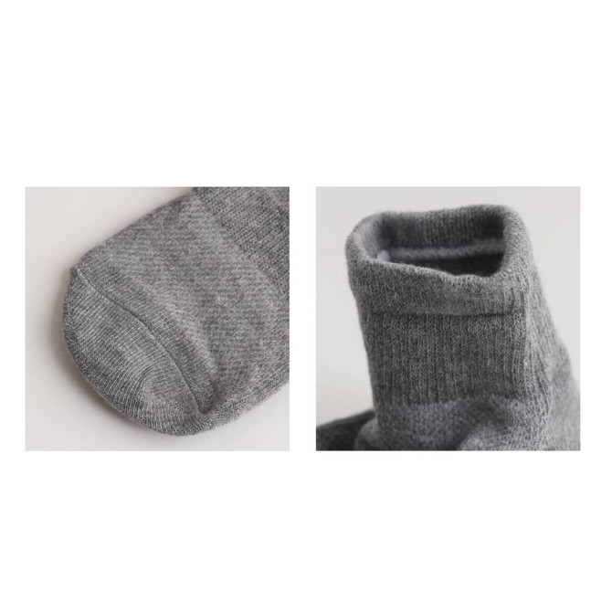 A pair of grey socks with a gripper design, featuring a close-up view of the toe and cuff sections.