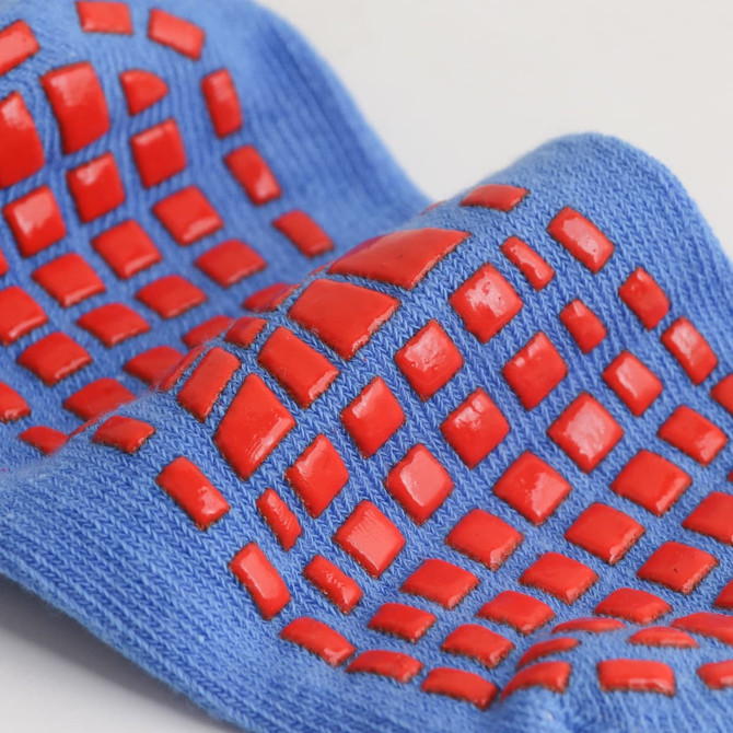 Blue kids' gripper socks featuring red non-slip dots for added traction. The fabric appears soft and flexible.