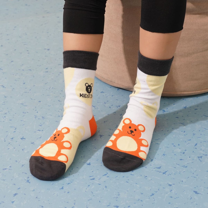 Brightly coloured woven socks featuring bear designs in orange, yellow, and black, with a contrasting dark grey cuff.