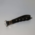 A black key chain stress reliever with popper buttons and a silver attachment ring.