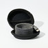 A charging cable in a round black case, featuring a sleek, woven design in grey tones.