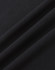 A close-up of black cotton fabric with a smooth texture, featuring subtle folds.