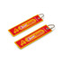 A red and yellow woven keytag featuring a pizza design and a branding logo, attached to a metal ring.