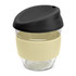A drink bottle featuring a clear borosilicate glass body, cream silicone grip, and a black lid.