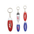 A set of four pill box keychains in red, white, and blue, featuring various logos and keyring attachments.
