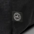 A black backpack made from recycled ocean plastic with a small logo patch.