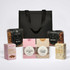 A black cooler bag filled with pretzels, beer nuts, and assorted sweet treats including coconut ice, caramel fudge, and marshmallows.