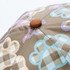 A cap featuring a textured pattern with colours including beige, purple, blue, and brown. It has a branding logo.