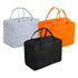 Three travel bags in grey, orange, and black felt material, featuring dual handles and a structured design.