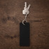 A black rectangular keychain attached to several metal keys on a wooden surface.