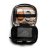 A black tech kit opened to reveal a drink bottle, orange case, cords, and a mesh pocket.
