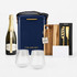 A navy hamper with a drink bottle, two crystal glasses, a wooden board, a corkscrew, and a card. It features branding.