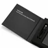 A black wireless power bank with a USB cable, displayed in a sleek box, featuring branding.