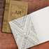 A brown notebook with a patterned cover and a blank, lined interior featuring geometric designs. It has a logo.