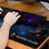 A dark blue gaming mat with a geometric design, featuring a logo and a gaming mouse and keyboard on it.