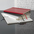 A collection of hard-bound journals in red, black, and silver, featuring ribbon bookmarks and lined pages.
