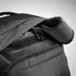 A black duffel backpack with a textured fabric and zippered opening, featuring padded shoulder straps.
