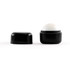 A black cube lip balm container with a white lip balm sphere on top, featuring a removable lid.