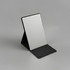 A compact mirror with a sleek black stand, featuring a reflective surface and a minimalist design.