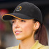 A black cap with an orange accent and a circular logo on the front, featuring a woman wearing it.