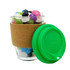 A glass coffee cup featuring a cork band and a green lid, filled with colourful jelly beans. The cup has a logo.