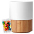 A white ceramic mug with a bamboo base alongside a packet of colourful jelly beans.