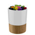 A ceramic mug with a wooden base filled with colourful jelly beans in various shades.