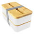 A two-tiered bamboo lunch box pack in white with a bamboo lid and a grey elastic strap for secure closure.