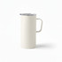 A travel mug in cream colour with a sturdy handle and a transparent lid. It features a branding logo.