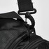 A close-up of a black duffle bag strap with a metal clip attachment. The bag has a textured surface.