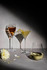 A set of three elegant glasses on a grey surface, featuring a stemmed wine glass, a martini glass, and a stemless wine glass.