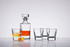 A whisky decanter set featuring a clear glass decanter and four matching tumblers, complemented by a twist of citrus peel.