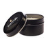 A black tin candle with an open lid, featuring a decorative label that includes stars and a crescent moon design.