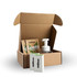A brown cardboard box containing a bottle with a pump, and two packets of laundry detergent.