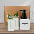 A white pump bottle with black lid beside three soap bars, placed in a brown box labelled "Laundry."