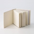 A tower note block featuring multiple stacks of blank pages in a neutral colour, with a simple, unbranded design.