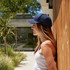 A navy blue cotton sandwich cap with a logo, displayed against a modern background.