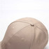 A beige cotton sandwich cap featuring six panels and a logo. The top view highlights its stitching details.