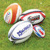A collection of four rugby balls in various designs and colours, resting on green grass. Each has unique branding.
