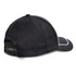 A black cap with a curved brim, featuring a contrasting white detail and an adjustable strap at the back.