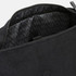 A black canvas backpack with a textured interior lining and a zippered opening. It features a logo.