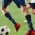 A pair of mid-calf socks in navy with a custom pattern, featuring a logo, worn during a soccer game.