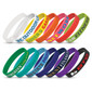 A collection of silicone wristbands in various colours, featuring debossed text and logos.
