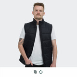 A black puffer vest with a high collar and a zip front, worn by a person standing against a neutral background.